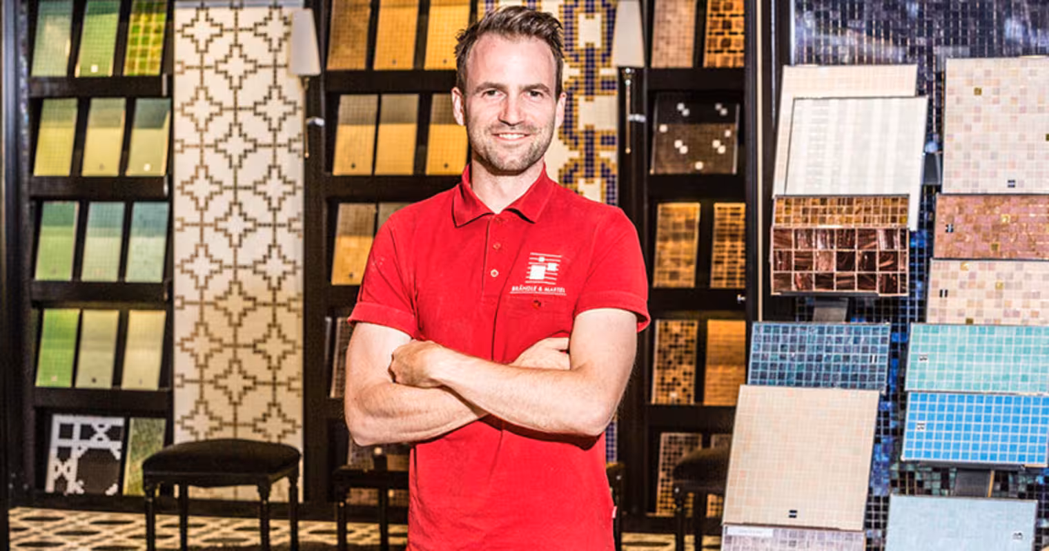 Ein Mann steht vor einem Regal mit Fließen.